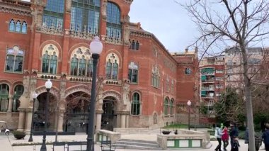 Canlı tarihi mimari, karmaşık tasarımı olan renkli tarihi mekan, tarihi öneme sahip süslü kırmızı tuğlalı hastane, detaylı tarihi el sanatları sergilenen canlı mimari anıt.