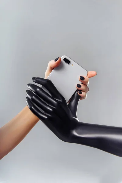 Black and white hands holding silver phone