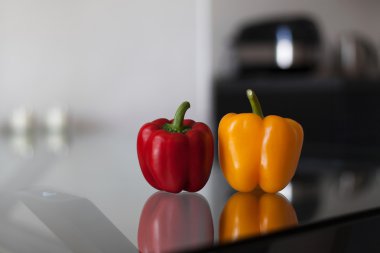 Cam masa üzerinde kırmızı ve sarı dolmalık biber