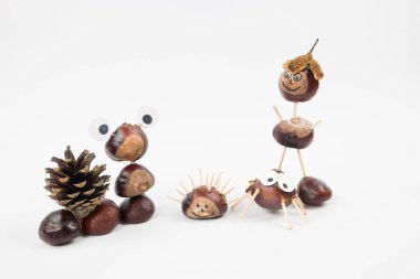 Beyaz arka planda kestane figürleri. Çocukla yaratıcı zaman geçirmek ve birlikte oynamak harika bir fikir. Doğada toplanın ve evde zanaat yapın..