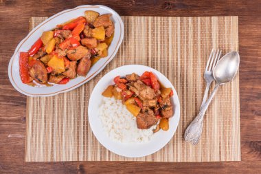 Oval tabakta ananas ve dolma biberli domuz eti ve bambu peçetesinde bir kase pilav. Filipin mutfağı.