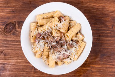 Pancetta 'lı makarna, siyah ahşap bir masada, yakın plan, üst manzara.