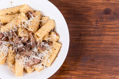 Pancetta 'lı makarna siyah tahta bir masada, yakın plan, üst görüş, kopyalama alanı