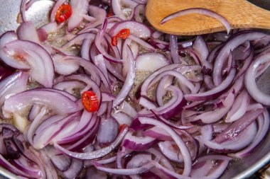 Spagetti alla vesuviana, soslu makarna, zeytin, soğan ve kapari - yakın planda kızartılmış kırmızı soğan.