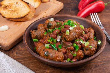 Geleneksel Teksas kovboy yemeği, domates soslu sığır sosisi ve ahşap bir masada kızarmış ekmek, yakın plan.