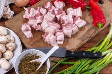 Ahşap bir masada doğu usulü mantarlı baharatlı domuz eti pişirmek için gerekli malzemeler.