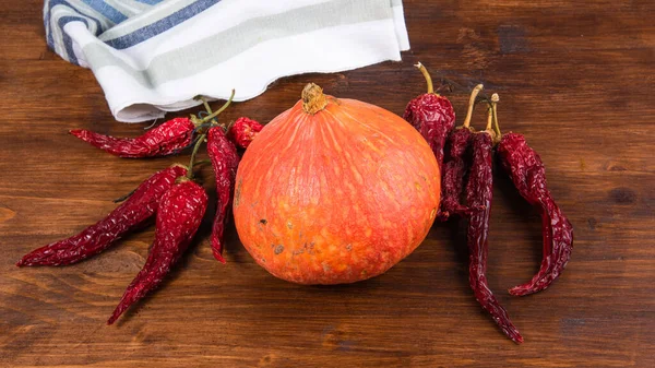 Small Orange Pumpkin Dry Hot Chilli Peppers Wooden Table — Stock Photo, Image