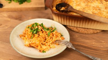 Domates soslu Girandole makarnasıyla ahşap bir masada peynirli İtalyan mutfağı.