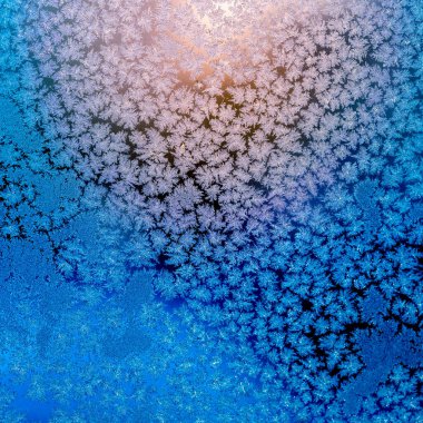 Donmuş bir penceredeki buz desenleri ve pencerenin dışındaki yükselen güneşten gelen ışık - kış arkaplanı