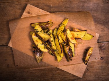 Ahşap bir tahtanın üzerinde, ahşap bir arka planda, tepeden bakıldığında kırsal patates.