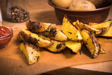 Ahşap bir tahta üzerinde Rustik fırında patates ve sos ve köhne ahşap bir masada baharatlar, yakın plan.