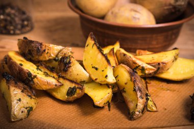 Ahşap bir tahta üzerinde Rustik fırında patates ve sos ve köhne ahşap bir masada baharatlar, yakın plan.