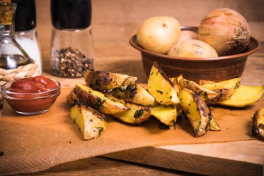 Ahşap bir tahta üzerinde Rustik fırında patates ve sos ve köhne ahşap bir masada baharatlar, yakın plan.