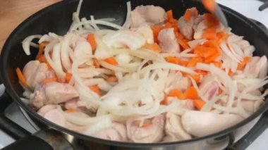 Tavada havuç ve soğan ile körili tavuk pişirmek, yakın plan.