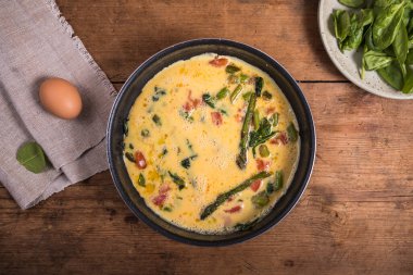 Kuşkonmaz, domates ve ıspanakla omlet pişirmek - tavaya kuşkonmaz, domates ve ıspanakla karışık yumurta dökmek.