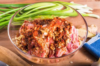 Acı sosla marine edilmiş çiğ domuz eti ve cam bir kasede sarımsak - domuz pişirme