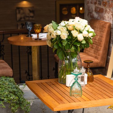 Boş bir kafedeki masada bir buket beyaz gül.