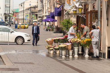 Moskova, Rusya, 27 Temmuz 2020 Moskova 'da sıradan bir şehir hayatı. Takım elbiseli bir adam sokakta yürür ve çiçekçiye gider.