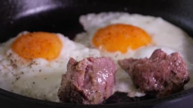 Basit bir erkek yiyeceği. Fırında pişmiş et parçalarıyla pişirilmiş yumurta. Dökme demir tavada.