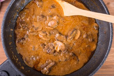 Büyük bir tavada sığır eti ve mantarlı ev yapımı stroganof. Yakın plan, üst manzara.