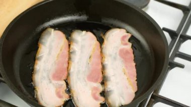 Pastırma dökme demir bir tavada kızartılıyor. Yakın plan.