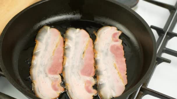 Bacon is fried in a cast iron pan - close-up — Stock Video