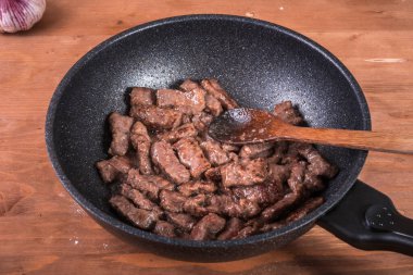Biftek pişirmek - tavada kızarmış et parçaları, bifteğin ilk adımı.