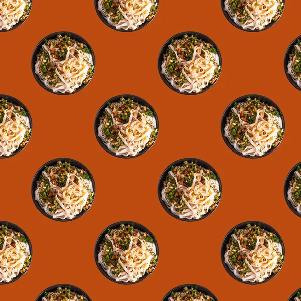 Kitchen food pattern, asian food, flat lay - rice noodles with hot sauce with herbs in bowls on orange background, vergetarian pattern