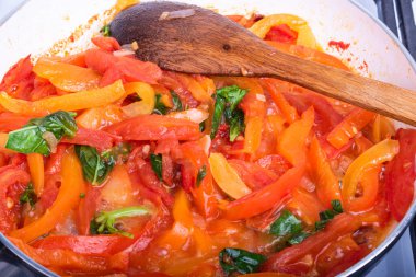 Biberli salsa sosu, domates ve fesleğen kızartma tavasında, yakın plan.