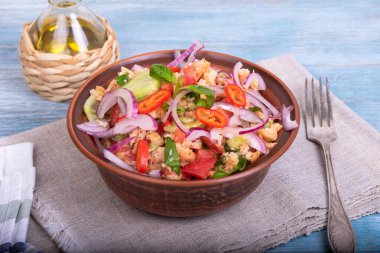 Ev yapımı Tuscan panzanella salatası. Masada çatal ve bir sürahi zeytinyağı var. Yakın plan.