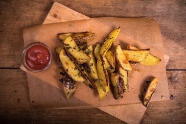 Baharatsız, fırında patates dilimleri ve bir fincan domates soslu boya.