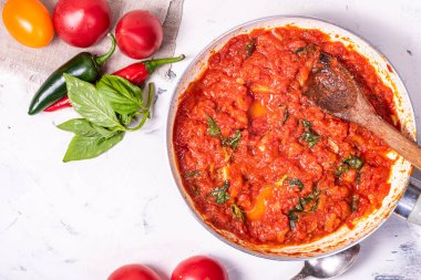 Kızartma tavasında domates sosu ve masada yapmak için malzemeler, fotokopi alanı, üst manzara, düz yatış
