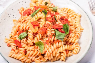 Girandole marinara makarnası fesleğen ve biberli tabakta - üst manzara, yakın çekim
