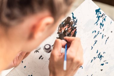 Kadınlar bir resmi sayılarla boyar, seçici bir odak ile.