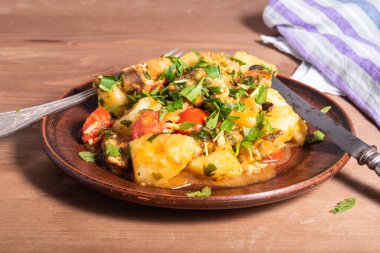 Köy usulü vejetaryen patates, domates, soğan ve biber güveci masada, yakın plan.