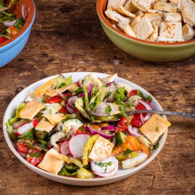 Arap vejetaryen salatası. Domates, soğan, salatalık ve biber. Masada pide ve kızarmış ekmek var.