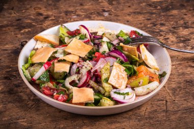 Suriye ve Lübnan vejetaryen salatası. Domates, soğan, salatalık ve biber. Masada pide ekmekli kızarmış ekmek var.