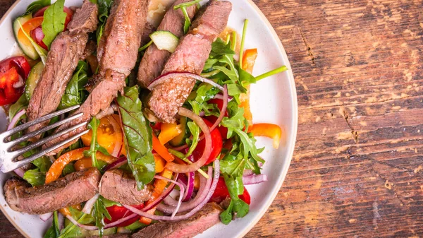 Sebze salatası ve masada biftek parçaları - sağlıklı yemek, kırsal stil, üst manzara, kopyalama alanı