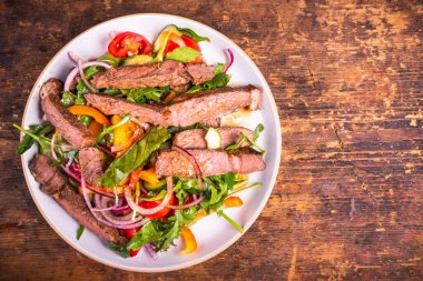 Biftek parçalı sebze salatası. Tabakta orta pişmiş olsun, üst manzara olsun, kopyalama alanı olsun.