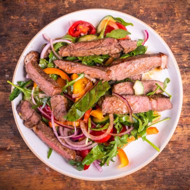 Sebzeli Tayland salatası ve biftek parçaları, tabakta porsiyon, üst manzara.