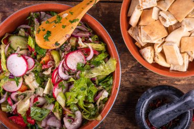 Sebzeli Arap yağlı salatası, sumac soslu ve masada pide krakeri.