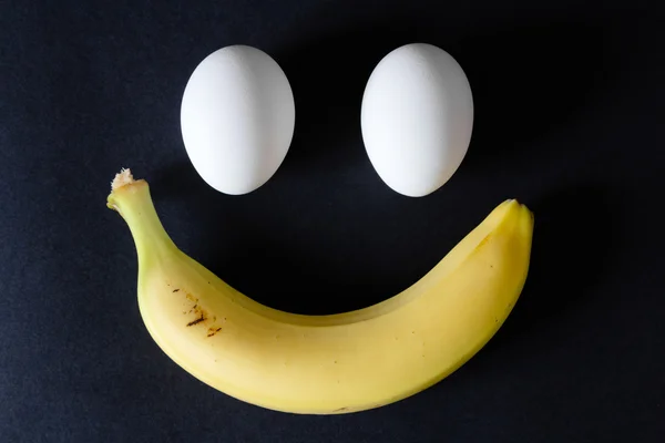 Eieren en banaan op zwarte achtergrond, close-up — Stockfoto