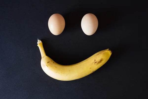 Jaja i banana na czarnym tle, z bliska — Zdjęcie stockowe
