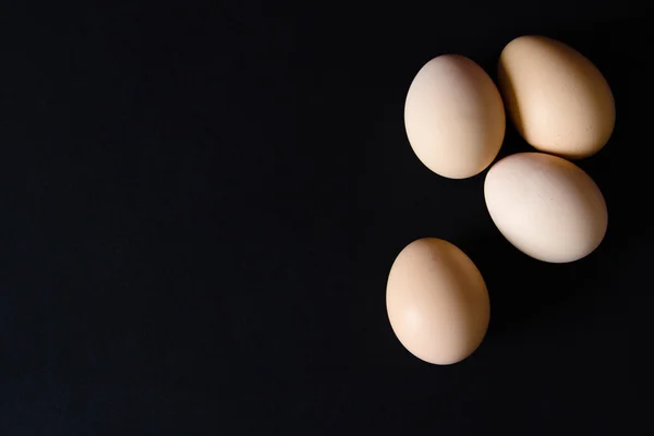 Несколько яиц на черном фоне — стоковое фото