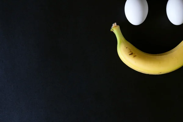 Huevos y plátano sobre fondo negro, de cerca — Foto de Stock