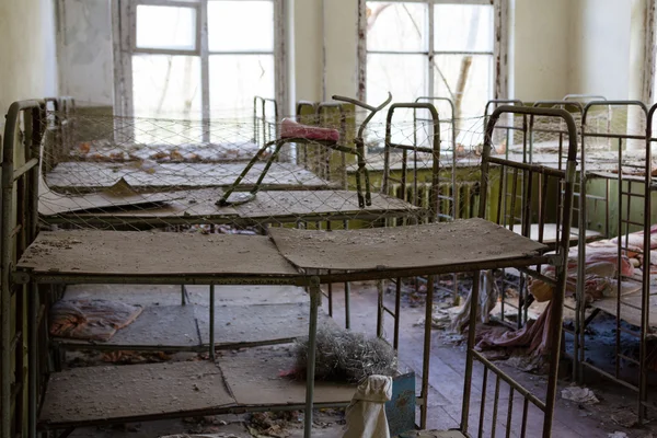 Oekraïne. Tsjernobyl uitsluiting Zone. -2016.03.19. Babybedjes in de slaapkamer op verlaten kleuterschool — Stockfoto