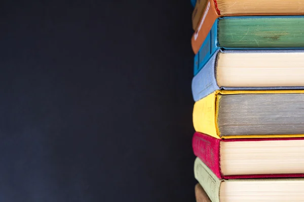 Siyah arkaplan üzerine kitap yığını