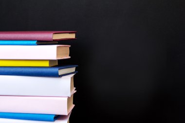 Siyah arkaplan üzerine kitap yığını