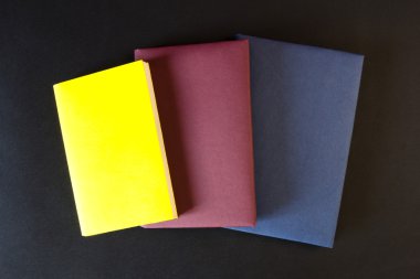 Siyah arkaplan üzerine kitap yığını