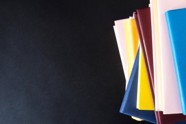 Siyah arkaplan üzerine kitap yığını
